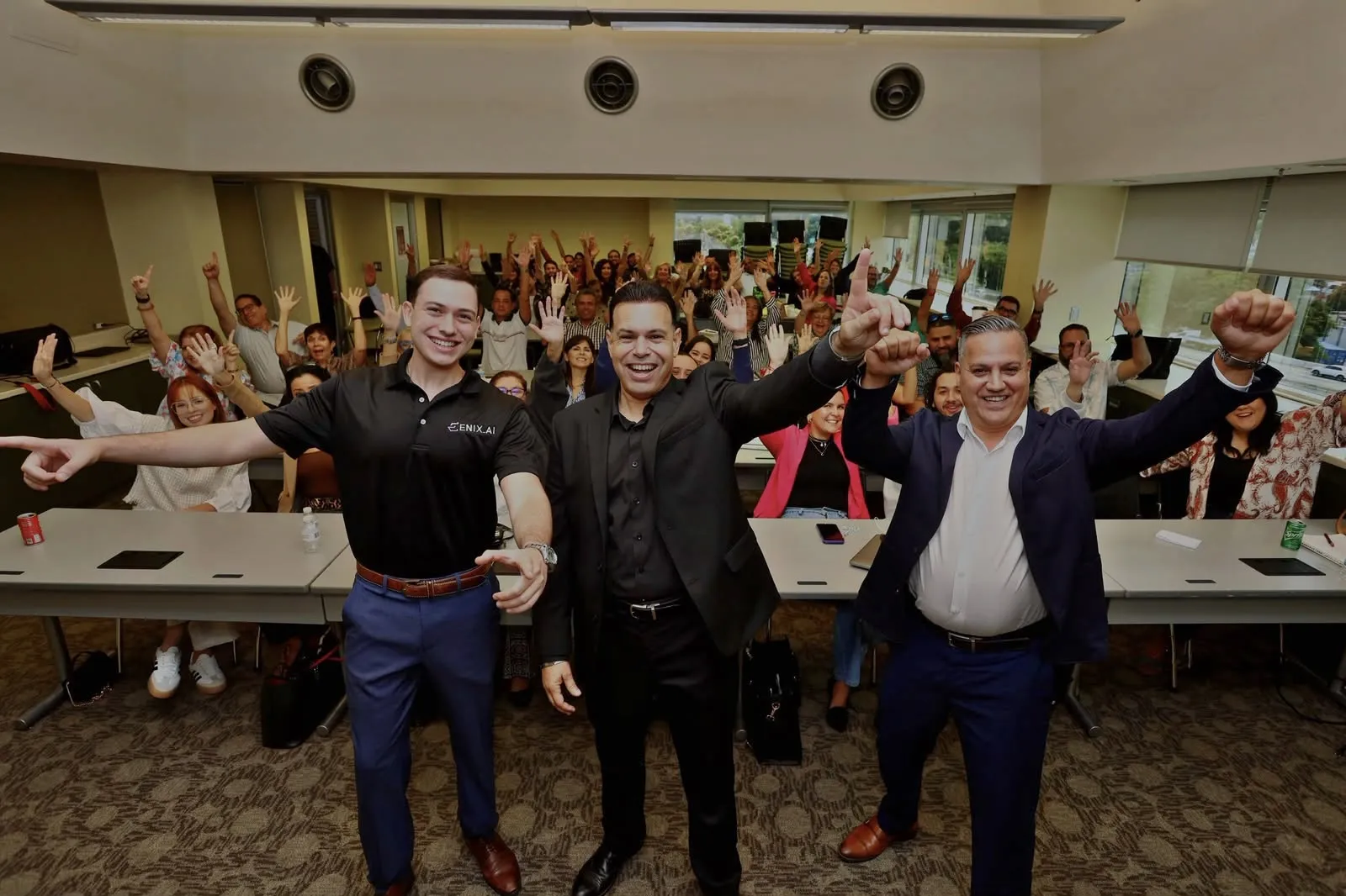 Christian Rivera junto a participantes de un bootcamp de ENIX.AI con las manos en alto